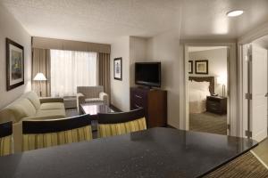 スコッツデールにあるホリデイ イン スコッツデール ノース エアパークのベッド、テーブル、椅子が備わるホテルルームです。