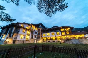 a lit up building with a fence in front of it at Oak Residence Hotel & Relax in Smolyan