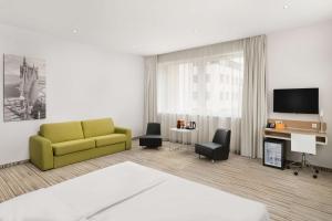 a living room with a yellow couch and a tv at Park Inn By Radisson Budapest in Budapest