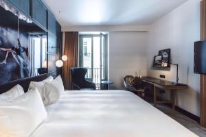a hotel room with a large bed and a desk at Radisson Blu Hotel, Madrid Prado in Madrid