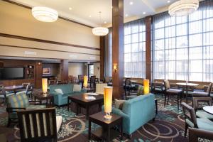 a hotel lobby with tables and chairs and windows at Staybridge Suites Toledo/Maumee, an IHG Hotel in Maumee