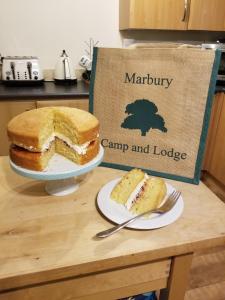 a table with a cake and a plate of cake at Marbury Camp and Lodge in Whitchurch