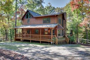 a large wooden house with a porch in the woods at Serenity Woods in Pleasant Hill