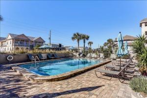 una piscina con sillas y sombrillas en Oceans Of Amelia, en Fernandina Beach