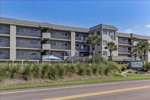Un edificio de apartamentos con palmeras frente a una carretera. en Oceans Of Amelia, en Fernandina Beach