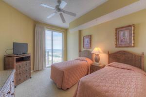 a bedroom with two beds and a tv and a window at Dunes of Seagrove Condos in Santa Rosa Beach