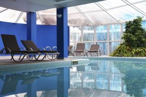 a swimming pool with chairs and a blue wall at Hotel O Colmo in Santana