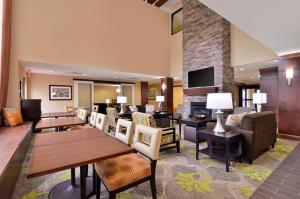 a hotel room with tables and chairs and a fireplace at Staybridge Suites Tomball, an IHG Hotel in Tomball