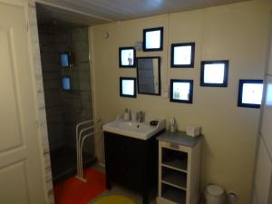 ein Badezimmer mit einem Waschbecken und Bildern an der Wand in der Unterkunft Chez Carole et Roger in Avignon