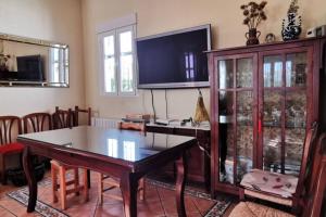 sala de estar con mesa y TV en Balcón de la Alhambra y Sierra Nevada en Huétor Vega