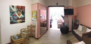 a living room with a couch and a mirror at Hotel Zen in Lignano Sabbiadoro
