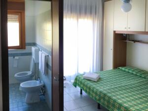 bagno con letto, servizi igienici e lavandino di Hotel Zen a Lignano Sabbiadoro