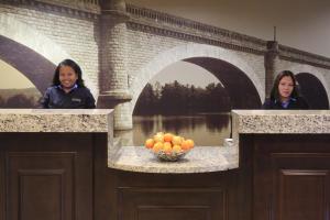 two women standing in front of a bridge with a bowl of fruit at Staybridge Suites Silicon Valley - Milpitas by IHG in Milpitas +43 photos