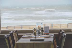 a table in a restaurant with a view of the ocean at Strandhotel De Haan in De Haan