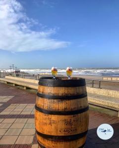 two birds sitting on top of a barrel near the beach at Strandhotel De Haan in De Haan