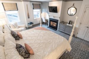 a bedroom with a large bed and a fireplace at The Whaler's Inn in Mystic