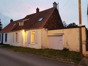 een wit huis met een garage aan de straatkant bij Maison de Charme à Wissant in Wissant