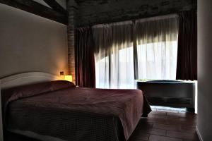 una camera con un letto e una grande finestra di Blue Garibaldi Room & Breakfast a Soragna