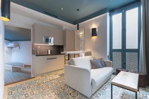 a living room with a couch and a kitchen at Apartamentos Caminante del Agua in Seville