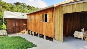 un edificio de madera con garaje y una casa en Pousada Bica D'Água, en Lages