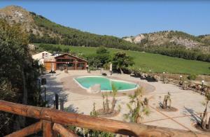 a resort with a swimming pool in front of a mountain at Agriturismo Tenute Pispisa Segesta in Calatafimi
