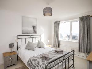 a bedroom with a bed and a large window at Swn y Mor Sound of the Sea in Criccieth