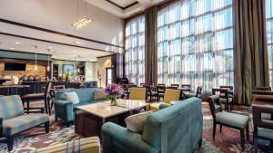 a lobby with blue chairs and tables and windows at Staybridge Suites Houston-NASA Clear Lake by IHG in Webster