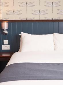 a bed with a white comforter and pillows at Corner House Inn by Greene King Inns in Newcastle upon Tyne