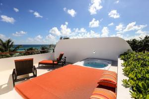 a patio with a table and chairs and a hot tub at The Beach Tulum in Tulum