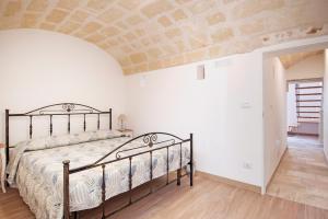 ein Schlafzimmer mit einem Bett in einem Zimmer mit einer Steinmauer in der Unterkunft Apulianstay-Via Cavour 22 in Monopoli