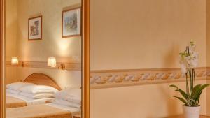sypialnia z lustrem i łóżkiem z ręcznikami w obiekcie Hotel Washington w Rzymie