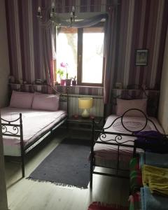 een slaapkamer met 2 bedden en een raam bij Къща за гости Спасителна in Brezhani