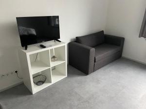 uma sala de estar com uma televisão e um sofá em Aachener Ferienwohnung em Aachen