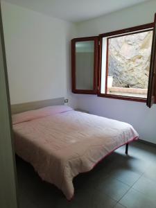 a bedroom with a bed and a window at Appartamenti Amaretto e Pardula in Fluminimaggiore