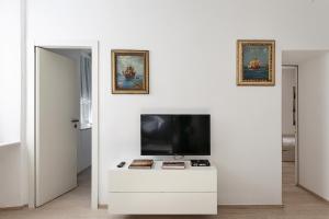 ein Wohnzimmer mit einem TV an einer weißen Wand in der Unterkunft Casa Colombo by Wonderful Italy in Genua