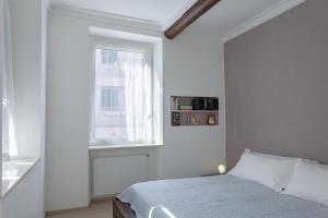 a white bedroom with a bed and a window at Casa Colombo by Wonderful Italy in Genoa