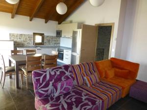 ein Wohnzimmer mit Couch und Tisch und eine Küche in der Unterkunft La Solana de Jaca- Casa La Sierra in Novés