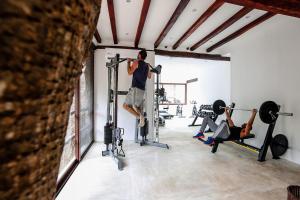 a man in a gym doing squats on a machine at The Beach Tulum Hotel in Tulum