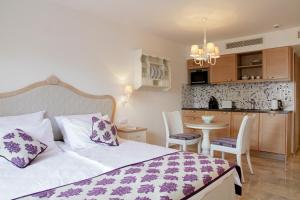 a bedroom with a bed and a small kitchen at Hapimag Apartments La Madrague in La Madrague