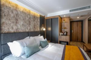 una camera da letto con un grande letto bianco con cuscini blu di Kayhan City Hotel a Bursa Altre 29 foto
