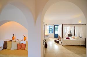 a bedroom with a bed and an archway at Tamarix Del Mar Suites in Kamari