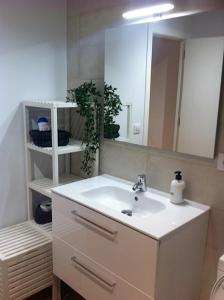 uma casa de banho com um lavatório branco e um espelho. em Corazón de Nervión, excelente ubicación, opcion PARKING em Sevilha