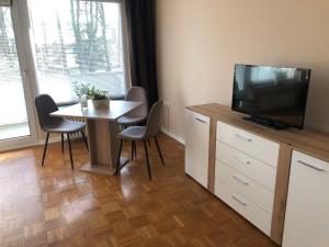 uma sala de estar com uma mesa e uma televisão e uma mesa e cadeiras em Super Lage, neu renovierte, gemütliche Unterkunft em Lübeck