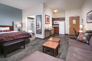 a hotel room with a bed and a living room at Staybridge Suites Augusta by IHG in Augusta