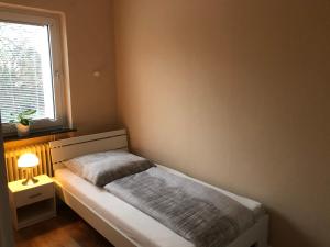 Habitación pequeña con cama y ventana en Super Lage, neu renovierte, gemütliche Unterkunft en Lübeck