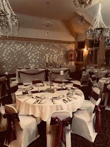 Minworth墨鱼桥酒店 - NEC /伯明翰机场 的用餐室配有白色桌椅和吊灯。