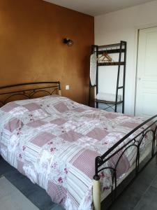 ein Schlafzimmer mit einem Bett mit einer rosa und weißen Decke in der Unterkunft Le Jardin in Lison