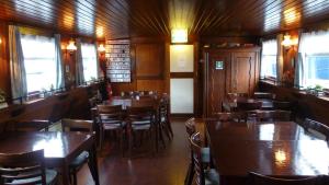 a restaurant with wooden tables and chairs and windows at Anna Maria II in Amsterdam