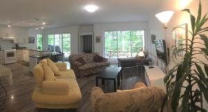 a living room with two couches and a kitchen at Club Loisirs Nautiques Quebec in Lac-aux-Sables