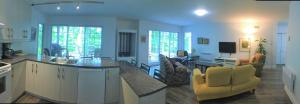 a kitchen and living room with yellow chairs and a table at Club Loisirs Nautiques Quebec in Lac-aux-Sables